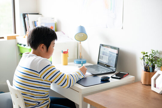 自宅でパソコンの前で勉強をしている男の子