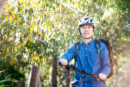 自転車に乗っているるフードデリバリー配達員男性