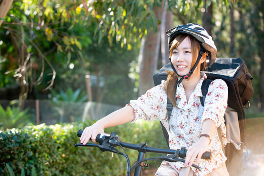 自転車に乗っているるフードデリバリー配達員女性