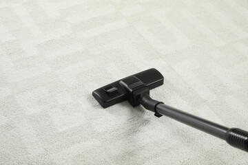 Removing dirt from white carpet with modern vacuum cleaner