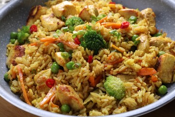 Tasty rice with meat and vegetables in frying pan, closeup