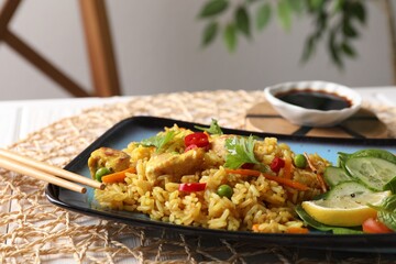 Tasty rice with meat and vegetables in plate on table, closeup