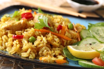 Tasty rice with meat and vegetables in plate on table, closeup