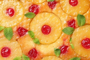 Fototapeta na wymiar Tasty pineapple cake with cherries and mint as background, top view
