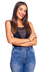 Fototapeta premium Young hispanic woman wearing casual clothes happy face smiling with crossed arms looking at the camera. positive person.