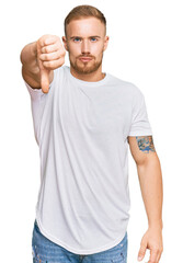 Young irish man wearing casual clothes looking unhappy and angry showing rejection and negative with thumbs down gesture. bad expression.