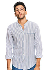 Fototapeta premium Young handsome man wearing casual clothes and glasses making fish face with lips, crazy and comical gesture. funny expression.
