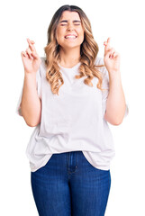 Obraz premium Young caucasian woman wearing casual clothes gesturing finger crossed smiling with hope and eyes closed. luck and superstitious concept.