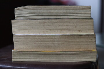 A Vertical Pile of old Dirty Books on a A stool