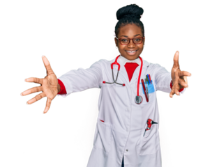 Young african american woman wearing doctor uniform and stethoscope looking at the camera smiling with open arms for hug. cheerful expression embracing happiness.