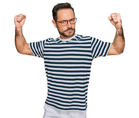 Middle age man wearing casual clothes and glasses showing arms muscles smiling proud. fitness concept.