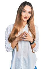 Beautiful caucasian woman wearing casual white shirt hands together and fingers crossed smiling relaxed and cheerful. success and optimistic