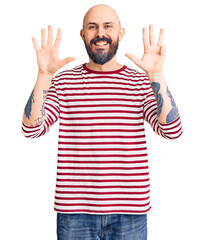 Young handsome man wearing casual clothes showing and pointing up with fingers number nine while...