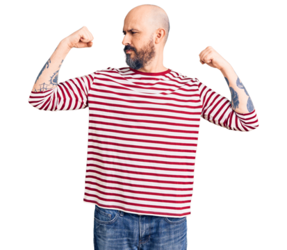 Young handsome man wearing casual clothes showing arms muscles smiling proud. fitness concept.