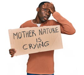 Young african american man holding mother nature is crying protest cardboard banner stressed and frustrated with hand on head, surprised and angry face