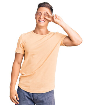 Young handsome man wearing casual clothes doing peace symbol with fingers over face, smiling cheerful showing victory