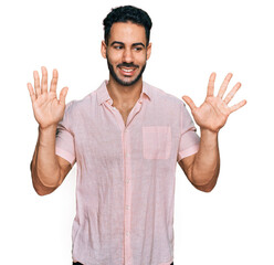 Hispanic man with beard wearing casual shirt showing and pointing up with fingers number ten while smiling confident and happy.