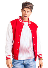 Young handsome man wearing baseball uniform in shock face, looking skeptical and sarcastic,...