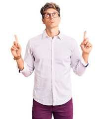 Young handsome man wearing business clothes and glasses pointing up looking sad and upset,...