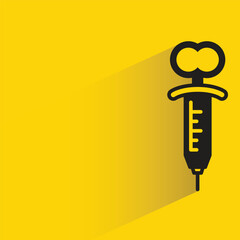 medical syringe with shadow on yellow background