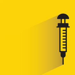 medical syringe with shadow on yellow background