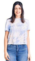 Obraz premium Young beautiful girl wearing casual t shirt winking looking at the camera with sexy expression, cheerful and happy face.