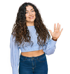 Young hispanic girl wearing casual clothes showing and pointing up with fingers number five while smiling confident and happy.