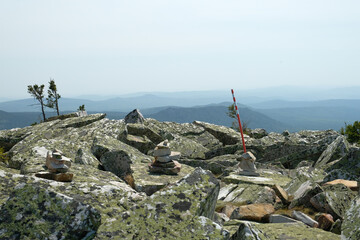 Panorama, landscape. In the foreground are rocks covered with moss, in the background are mountains. Summer, blue sky, day.