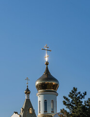 TRussian Orthodox Church, Ekaterinodar diocese. Temple of Kazan Icon of Mother of God. Golden domes with orthodox crosses against background of blue sky. Close-up. Krasnodar, Russia - October 27, 2021