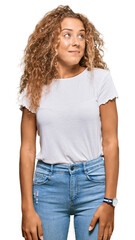 Obraz premium Beautiful caucasian teenager girl wearing casual white tshirt smiling looking to the side and staring away thinking.