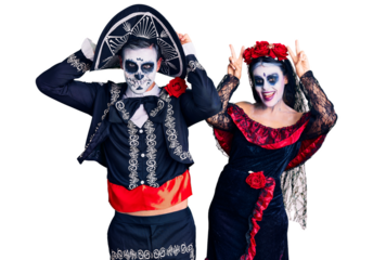 Young couple wearing mexican day of the dead costume over background posing funny and crazy with fingers on head as bunny ears, smiling cheerful