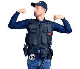 Young handsome man wearing police uniform showing arms muscles smiling proud. fitness concept.