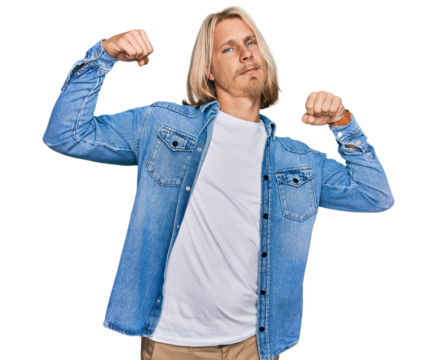 Caucasian man with blond long hair wearing casual denim jacket showing arms muscles smiling proud. fitness concept.
