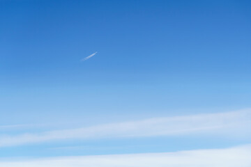 beautiful blue sky with soft clouds and a plane flying in the distance, abstract background, a view...