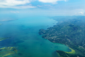 beautiful view of the coast of Montenegro from the height of an airplane flight, mountains and sea, blue sky with soft clouds, the concept of travel