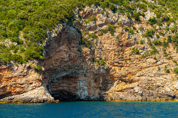 seascapes, a view of the rocks and a sea cave on the Bay of Kotor during a cruise on a ship in Montenegro, a bright sunny day, the concept of a summer trip