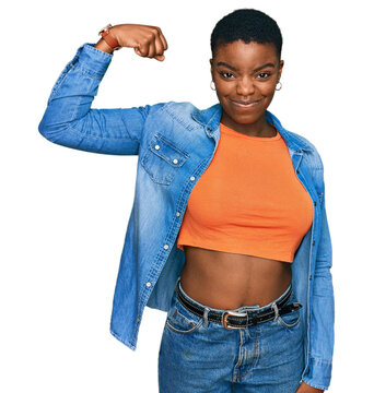 Young african american woman wearing casual clothes strong person showing arm muscle, confident and proud of power
