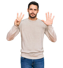 Young hispanic man wearing casual clothes showing and pointing up with fingers number eight while smiling confident and happy.