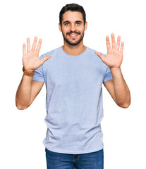 Young hispanic man wearing casual clothes showing and pointing up with fingers number ten while smiling confident and happy.
