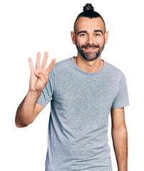 Hispanic man with ponytail wearing casual grey t shirt showing and pointing up with fingers number four while smiling confident and happy.