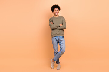 Fototapeta na wymiar Full size photo of positive cheerful good mood guy with afro hairstyle wear khaki shirt arms crossed isolated on beige color background