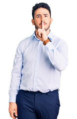 Young hispanic man wearing business clothes asking to be quiet with finger on lips. silence and secret concept.