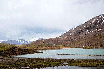 Mountain lake in the fog. Snowy peaks.