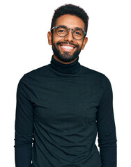 Young african american man wearing casual clothes looking positive and happy standing and smiling...