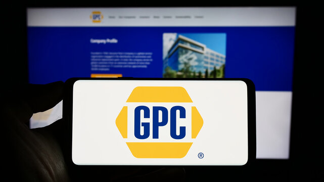 Stuttgart, Germany - 07-01-2023: Person holding smartphone with logo of US business Genuine Parts Company (GPC) on screen in front of website. Focus on phone display.