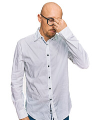 Bald man with beard wearing business shirt and glasses tired rubbing nose and eyes feeling fatigue and headache. stress and frustration concept.