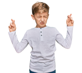 Little caucasian boy kid wearing casual clothes gesturing finger crossed smiling with hope and eyes closed. luck and superstitious concept.