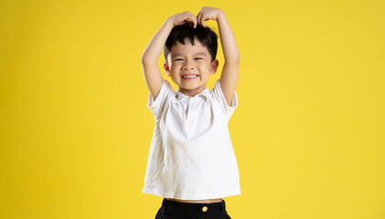 image of asian boy posing on a yellow background.