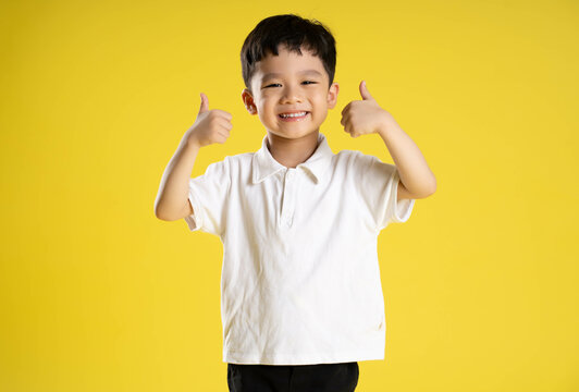 image of asian boy posing on a yellow background.