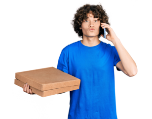 Caucasian teenager holding delivery package and talking by the smartphone looking at the camera blowing a kiss being lovely and sexy. love expression.